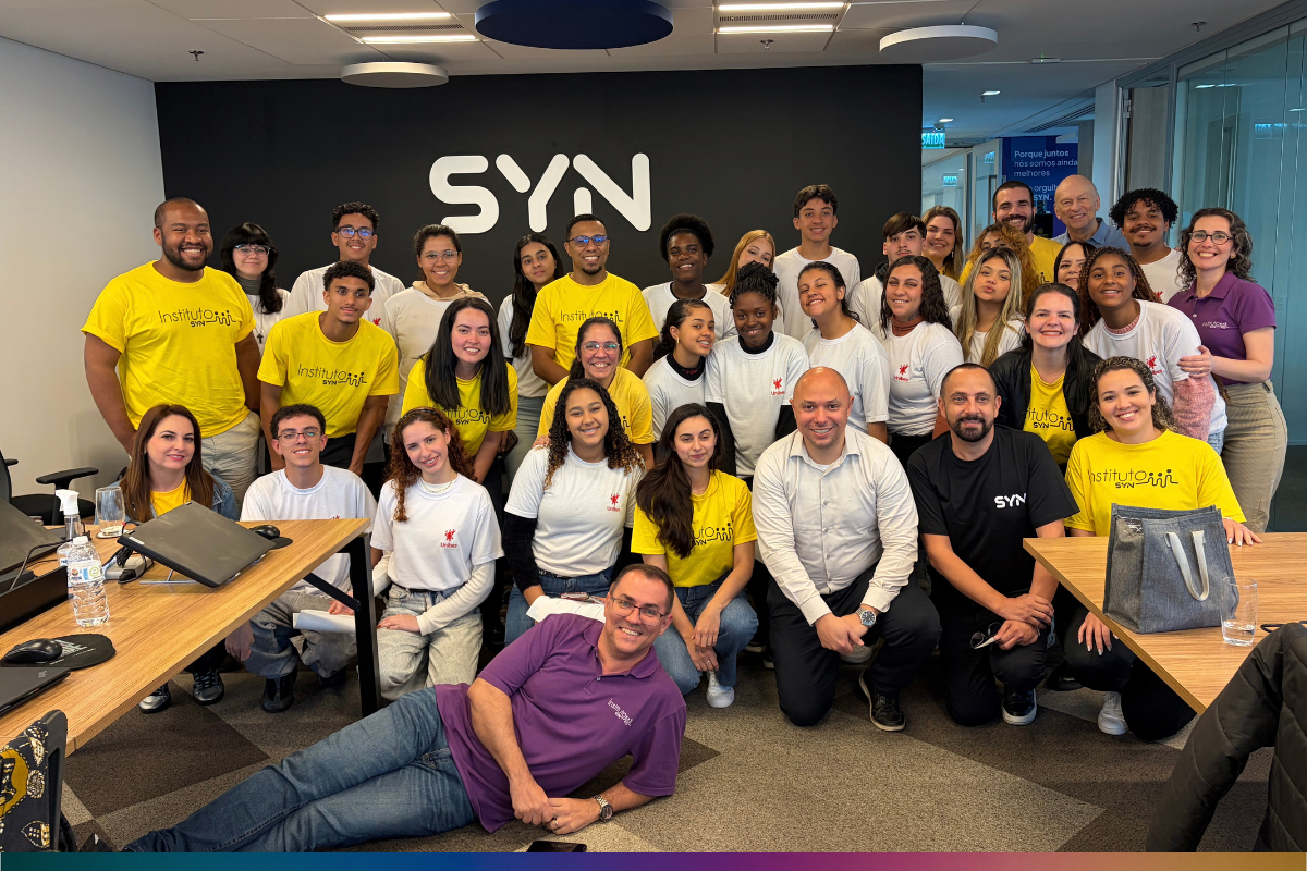 Voluntários do Instituto SYN e jovens participantes da ação Funcionário Sombra durante reunião no escritório corporativo.